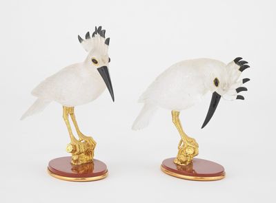 deux figurines d'oiseaux aux plumes noires et blanches, posées sur des socles en bois