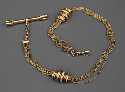 un collier en or et une paire de boucles d'oreilles posés sur une surface grise