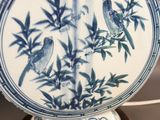 a blue and white vase with birds on it on a table