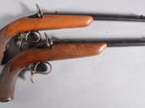 a pair of pistols with wooden handles on a white surface