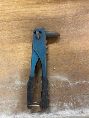 a blue pliers that is on a wooden table