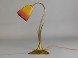 brass table lamp with a red and yellow shade on a white background