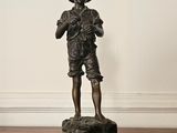 une statue représentant un garçon debout sur un socle