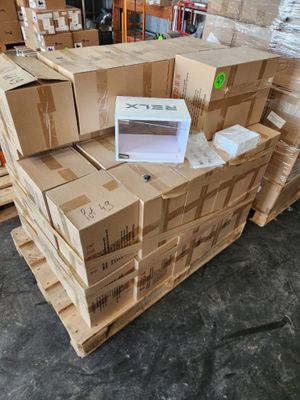 des cartons empilés les uns sur les autres dans un entrepôt, avec un ordinateur portable posé dessus