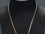 un collier en or orné d'un médaillon noir et blanc sur un mannequin