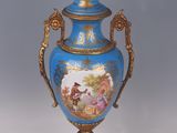 a blue vase with a painting on it sitting on a table