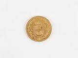a gold coin on a white surface with a white background