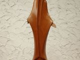 a brown sculpture on a white pedestal on a wooden table