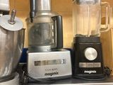 de nombreux mixeurs et blenders de toutes sortes posés sur une étagère