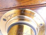 a close up of a clock on a wooden table