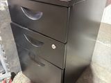 a black metal filing cabinet with two drawers on top of it