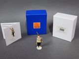 une figurine représentant un casse-noisette devant une boîte bleue