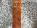 un livre marron posé sur une couverture grise