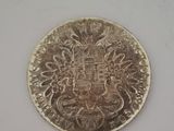 un gros plan d'une pièce d'argent sur laquelle figure un blason