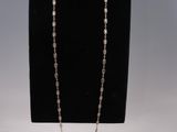 un ensemble composé d'un collier et de boucles d'oreilles, présenté sur un présentoir