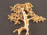 a gold tree brooch on a black surface