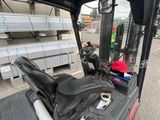 a forklift that is parked next to a pile of lumber