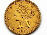 a close up of a gold coin with a woman ' s head on it