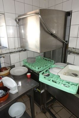 une cuisine où il y a beaucoup de vaisselle et de plats posés sur le plan de travail