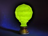 un vase en verre vert brillant posé sur un socle en bois, sur fond sombre