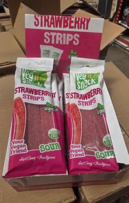 deux sachets de fraises sont posés sur une boîte en carton