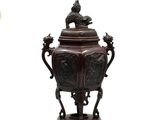 un grand vase marron surmonté d'un oiseau
