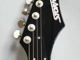 a black electric guitar that is hanging on the wall