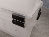 a plastic box with a lid on the floor
