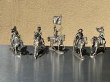 five figurines of people riding horses and holding flags