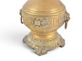 a gold vase that is sitting on a stand