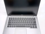a silver laptop with a black keyboard on a white surface