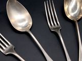 five spoons and a fork on a black table