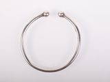gros plan d'un bracelet en argent sur une surface blanche
