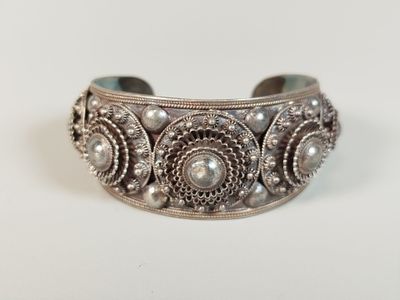 a close up of a silver bracelet with pearls on it