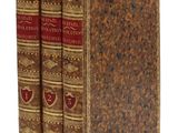 deux livres sont empilés l'un sur l'autre sur une surface blanche