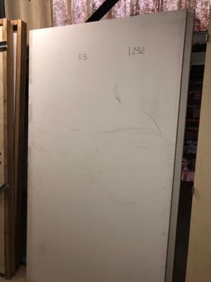 a refrigerator in the corner of a room next to a window