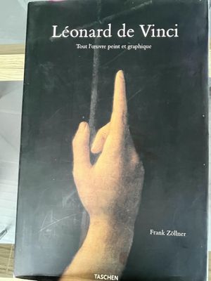 someone is holding a book in their hand on a table