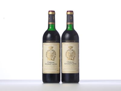 two bottles of wine sitting on top of a table next to each other