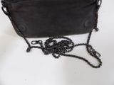 a black purse with a chain around it on a table