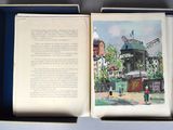 a open book with a picture of a windmill in the background