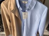 two shirts hanging on a hanger in a clothing store