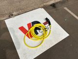 a yellow hose sitting on the ground next to a sign