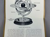 an open book with a picture of a model of the solar system