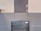 un lavabo en acier inoxydable dans des toilettes publiques, avec un distributeur de papier fixé au mur