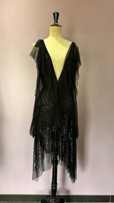 La robe est posée sur un mannequin devant un mur.