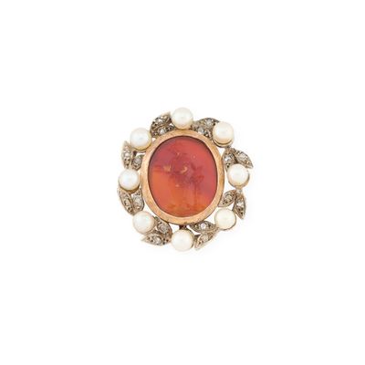 un gros plan d'une bague ornée de perles et d'une pierre orange