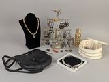 a black purse, a necklace, and other items on a table