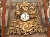 une horloge en or posée dans une vitrine, sur une table