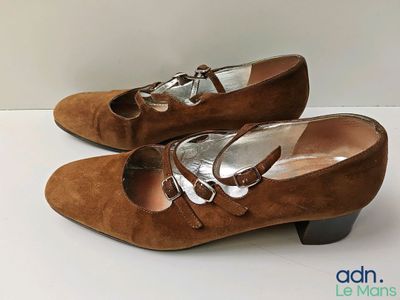 une paire de chaussures en daim marron pour femme posées sur une surface blanche