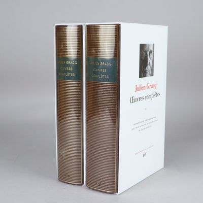 two books sitting on top of each other in front of a white box